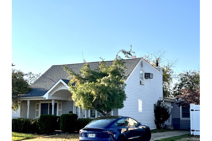 View of front of home with a shingled roof and a chimney