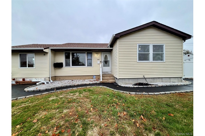 View of front facade with a shingled roof and a front lawn