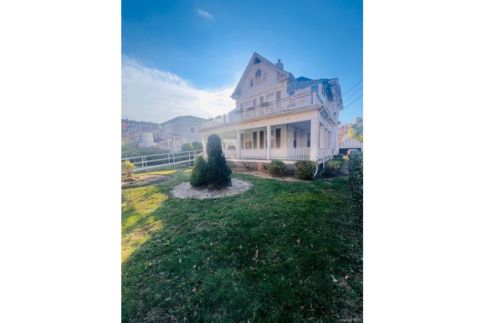 Back of house featuring covered porch and a chimney