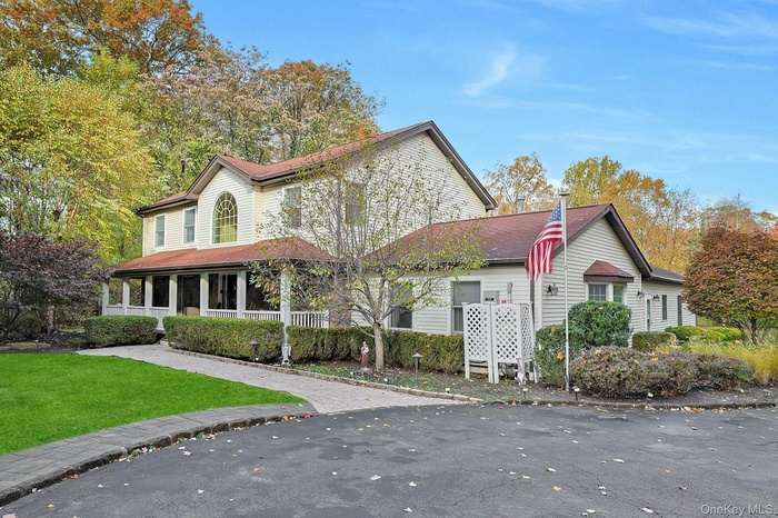 View of front of property with covered porch and a front lawn
