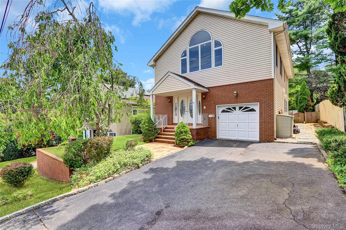Traditional home featuring brick siding, asphalt driveway, and a garage