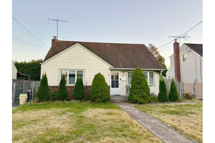 View of front of house with brick siding and roof with shingles