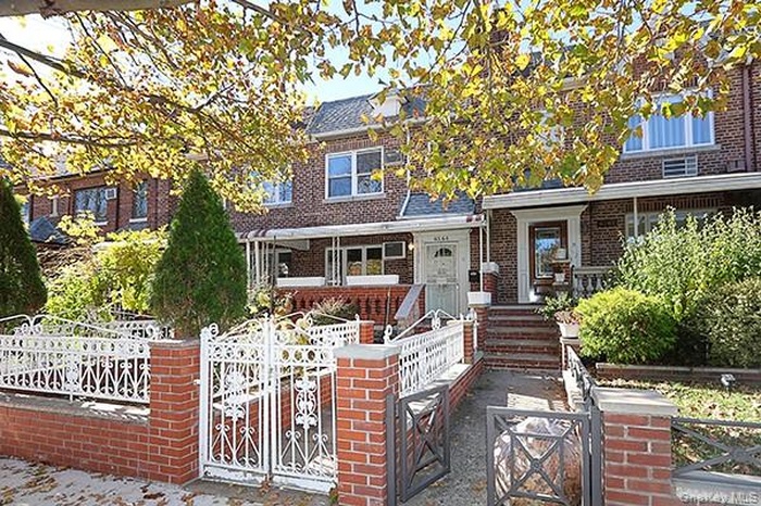View of front of house featuring a fenced front yard, a gate, and brick siding