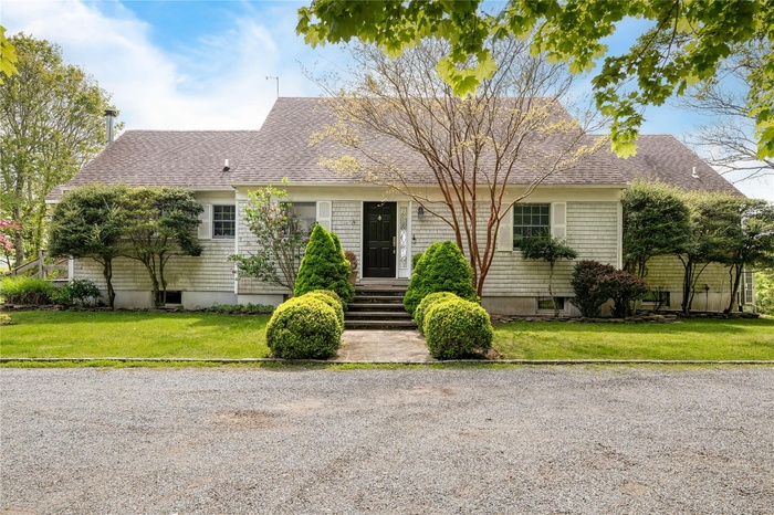 View of front of home featuring roof with shingles and a front yard