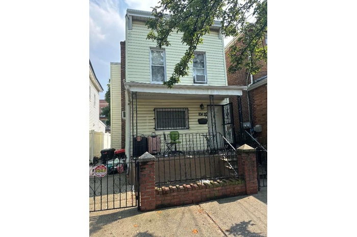 View of front facade with a porch, a fenced front yard, a gate, and cooling unit