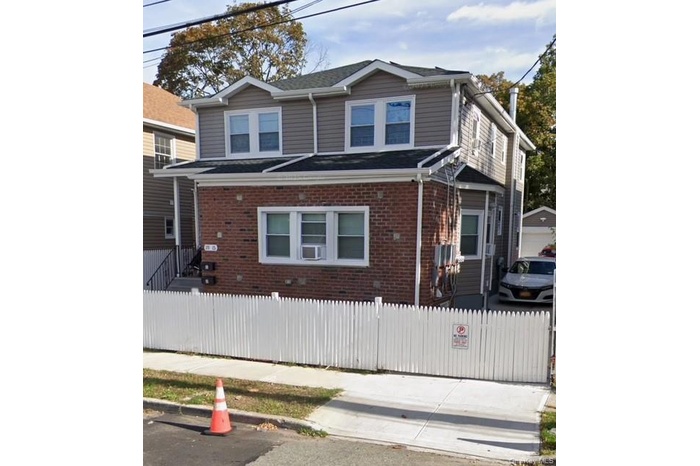 Traditional home with brick siding and a fenced front yard