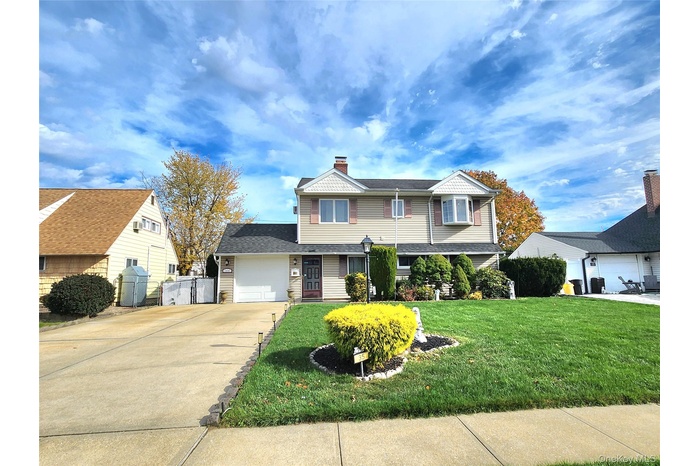 View of front facade with concrete driveway, a gate, and a garage