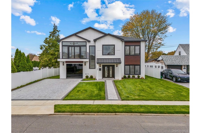 View of front of home featuring board and batten siding and decorative driveway