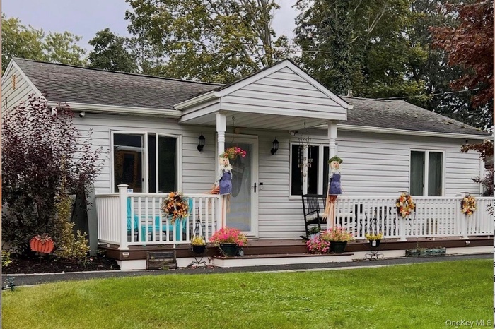 Bungalow with covered porch, a shingled roof, and a front yard