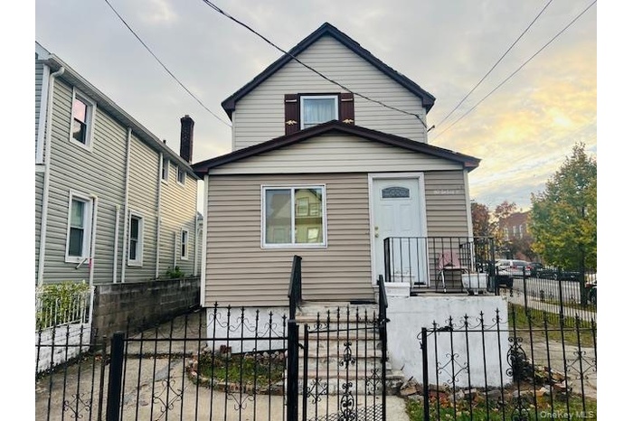 View of front of property featuring a fenced front yard and a gate