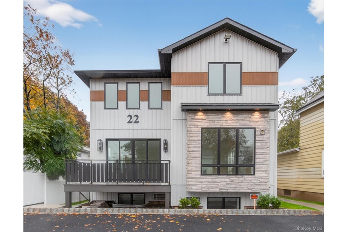 View of front of house featuring stone siding and a deck