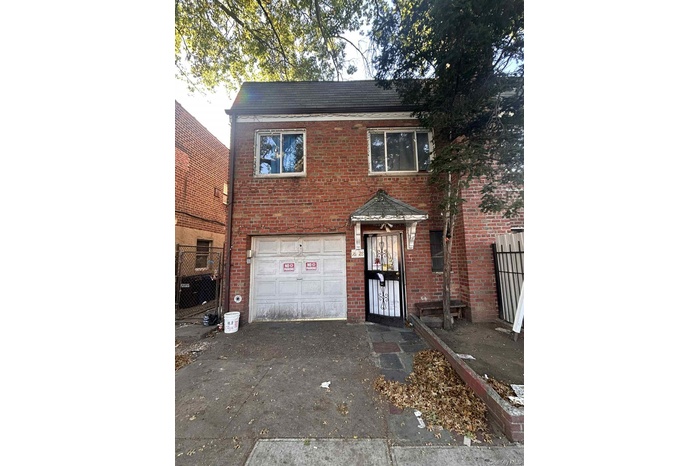 Traditional-style home with brick siding, driveway, and a garage