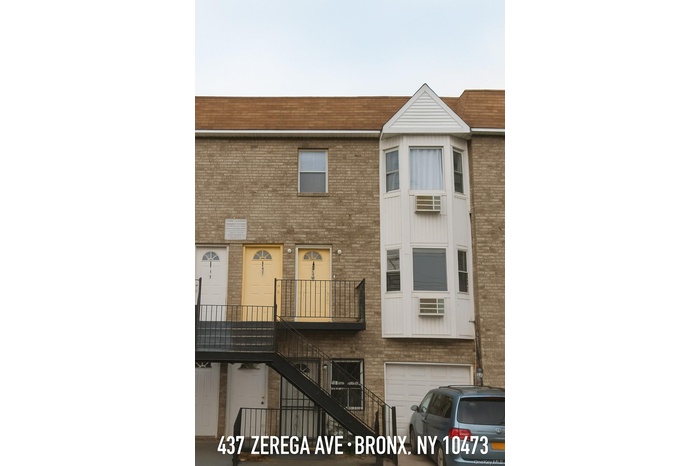 View of building exterior with stairs and a garage