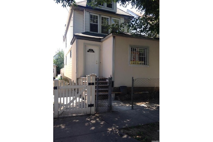 View of front of house featuring fence and a gate