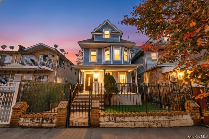 Traditional style home featuring a gate, a fenced front yard, and a porch