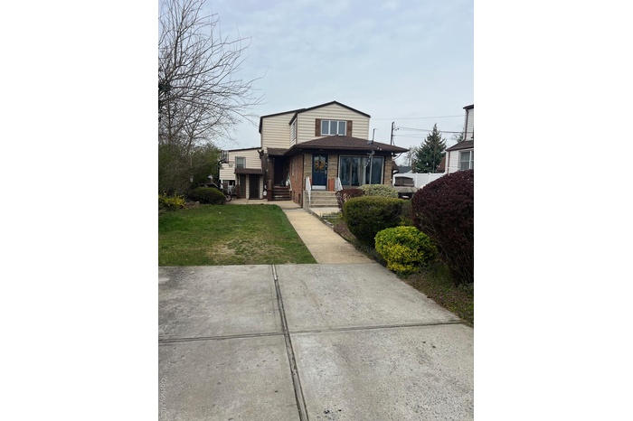 View of front facade with brick siding and a front yard