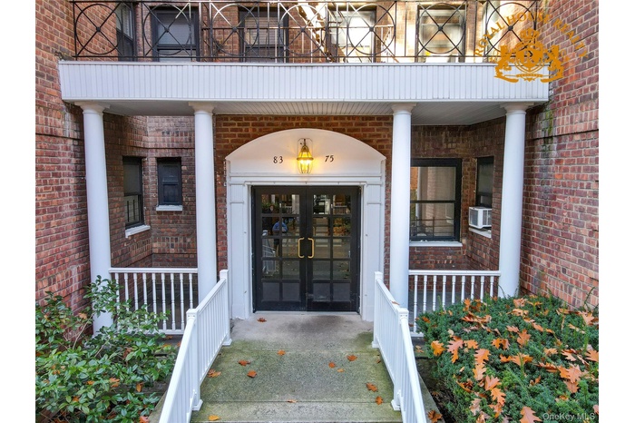 Doorway to property featuring brick siding and a porch