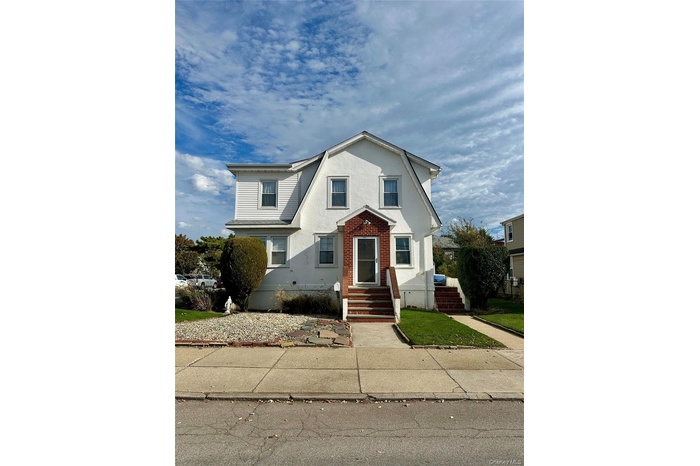 Dutch colonial with brick siding and entry steps