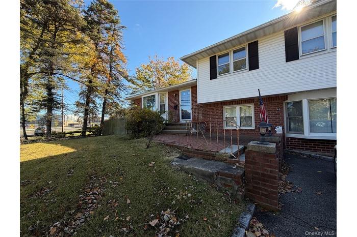 Split level home featuring brick siding and entry steps