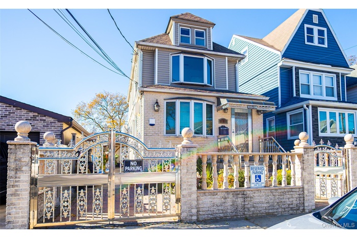 View of front of property featuring a gate, a shingled roof, and a fenced front yard