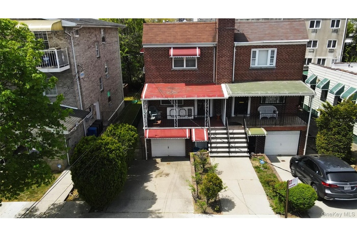 View of front facade featuring brick siding, a garage, driveway, and covered porch