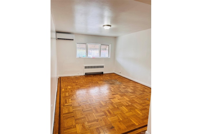 Spare room featuring radiator and a wall mounted AC