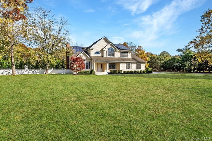 View of front of home with solar panels, a porch, and a chimney