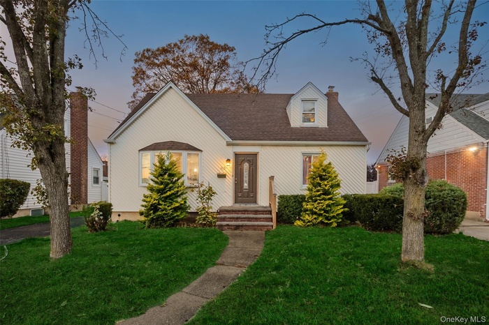 Cape cod home with a front lawn, a chimney, and a shingled roof