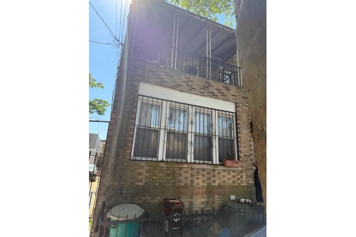 View of side of property featuring a balcony and brick siding