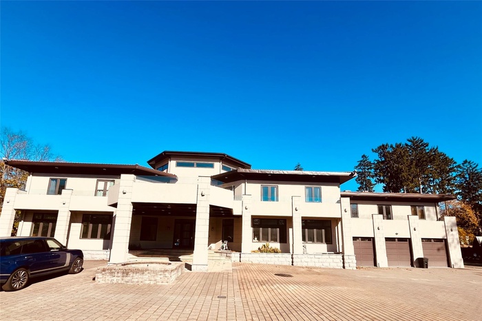 Modern home featuring stucco siding, a garage, and a balcony
