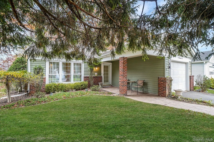 Front of house, front lawn, a garage, brick siding, and asphalt driveway