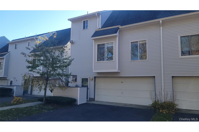 View of front of property featuring roof with shingles, driveway, and an attached garage