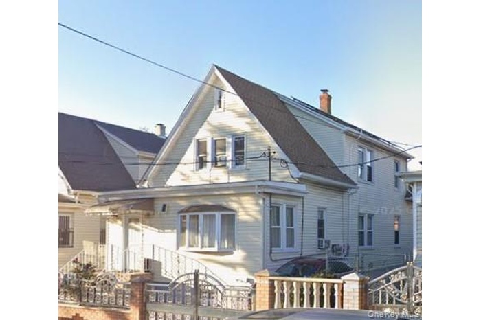 Back of house with a chimney and a fenced front yard