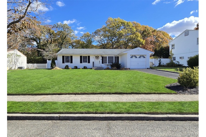 Ranch-style home with asphalt driveway and a garage