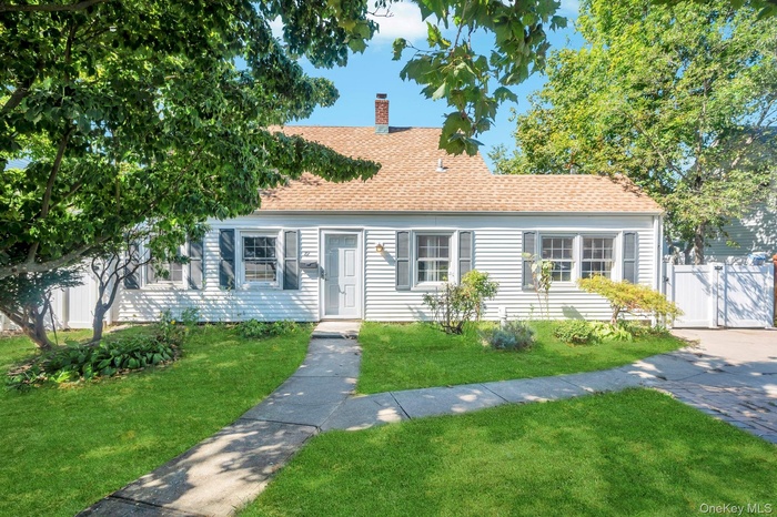 View of front of property featuring a chimney and roof with shingles