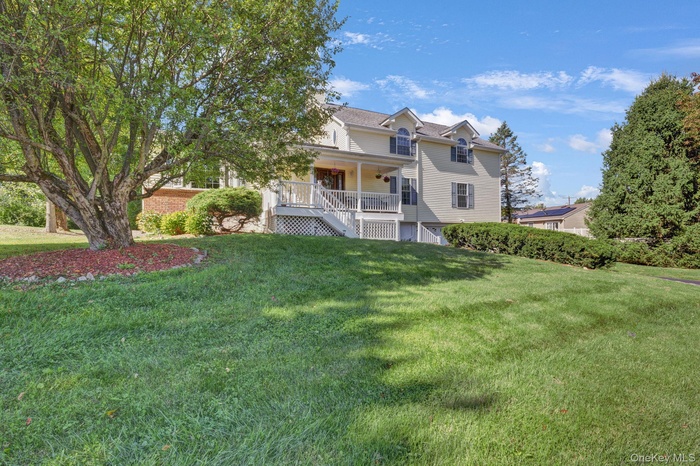 View of front of house featuring stairway, a front yard, and a porch