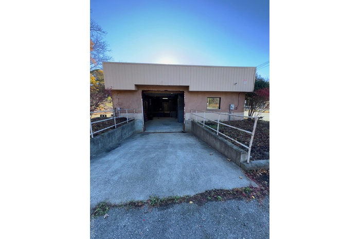 View of outdoor structure with driveway and an attached garage
