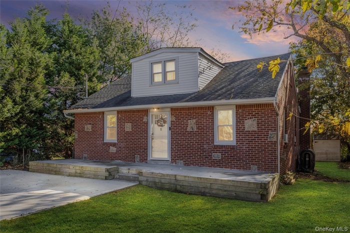 Bungalow with brick siding, a shingled roof, and a lawn