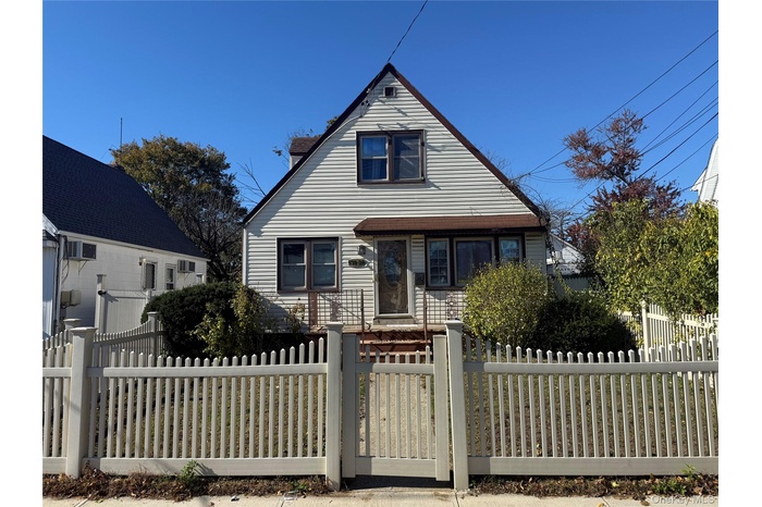 View of front of home featuring a gate, a fenced front yard, and a chimney