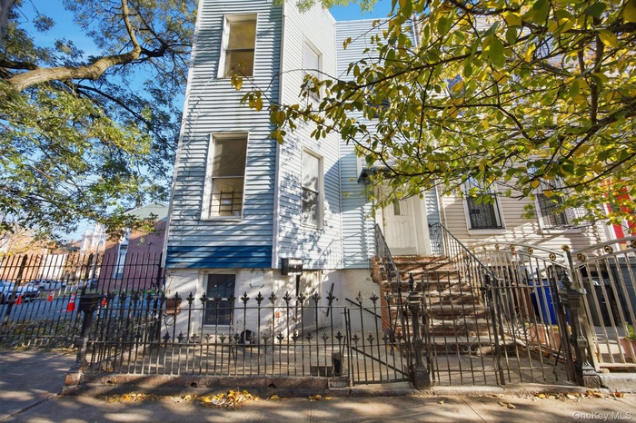 View of front facade featuring a fenced front yard and a gate