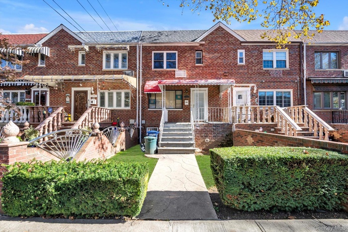 Traditional home featuring brick siding, roof with shingles, and a porch
