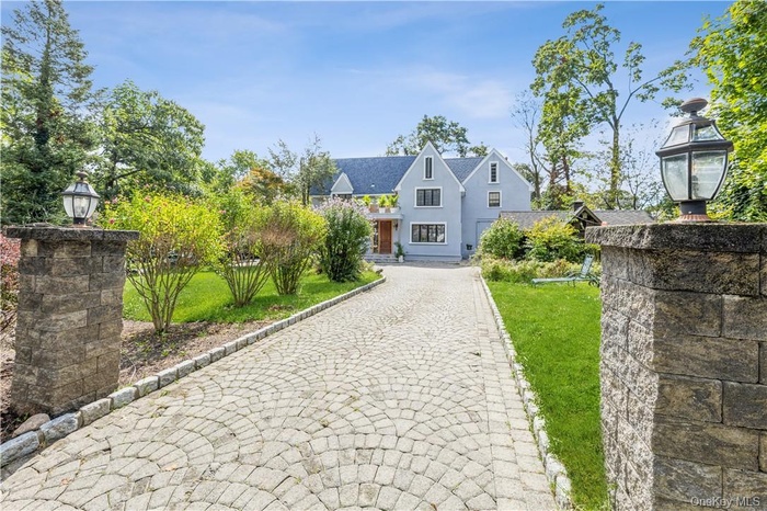 Spectacular, spacious, and sun-filled Tudor-style home featuring 4 bedrooms and 2.5 baths with paver circular driveway