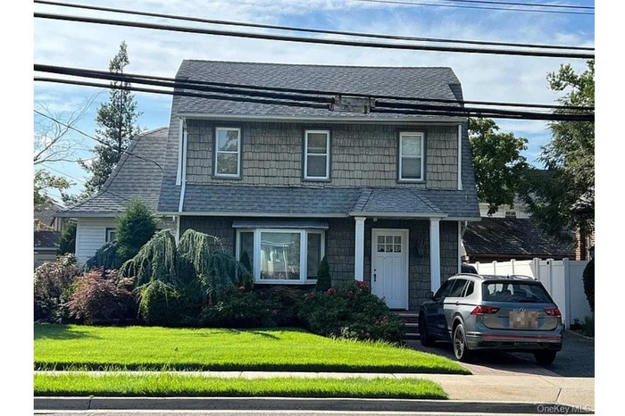 View of front of house with a shingled roof