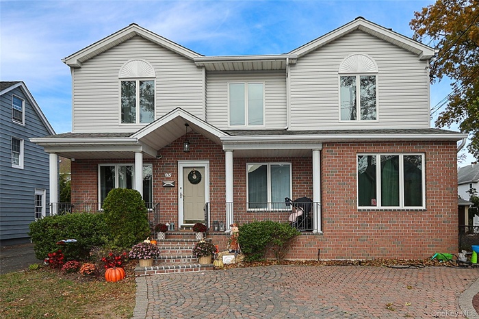 Traditional home featuring brick siding and covered porch