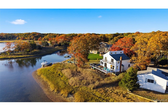 View from above of property featuring a forest and a nearby body of water