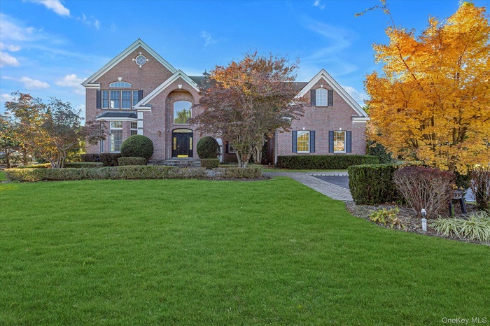 View of front of house featuring brick siding and a front lawn