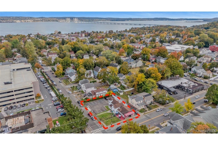 Aerial perspective of suburban area with a notable bridge and a nearby body of water