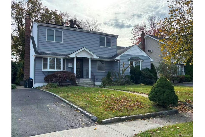 View of front facade with a front lawn and a chimney