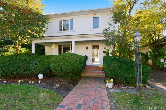 View of front of house with a porch and stucco siding
