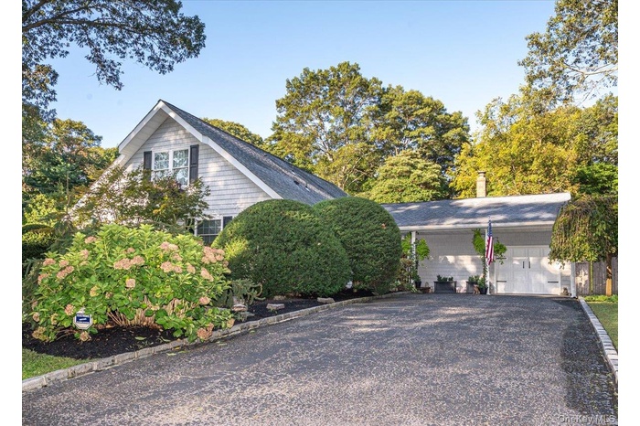 View of property exterior with gravel driveway and a garage